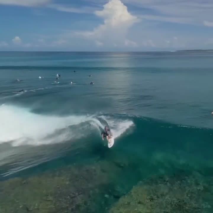 Surfer drawing a line across the face of a breaking wave