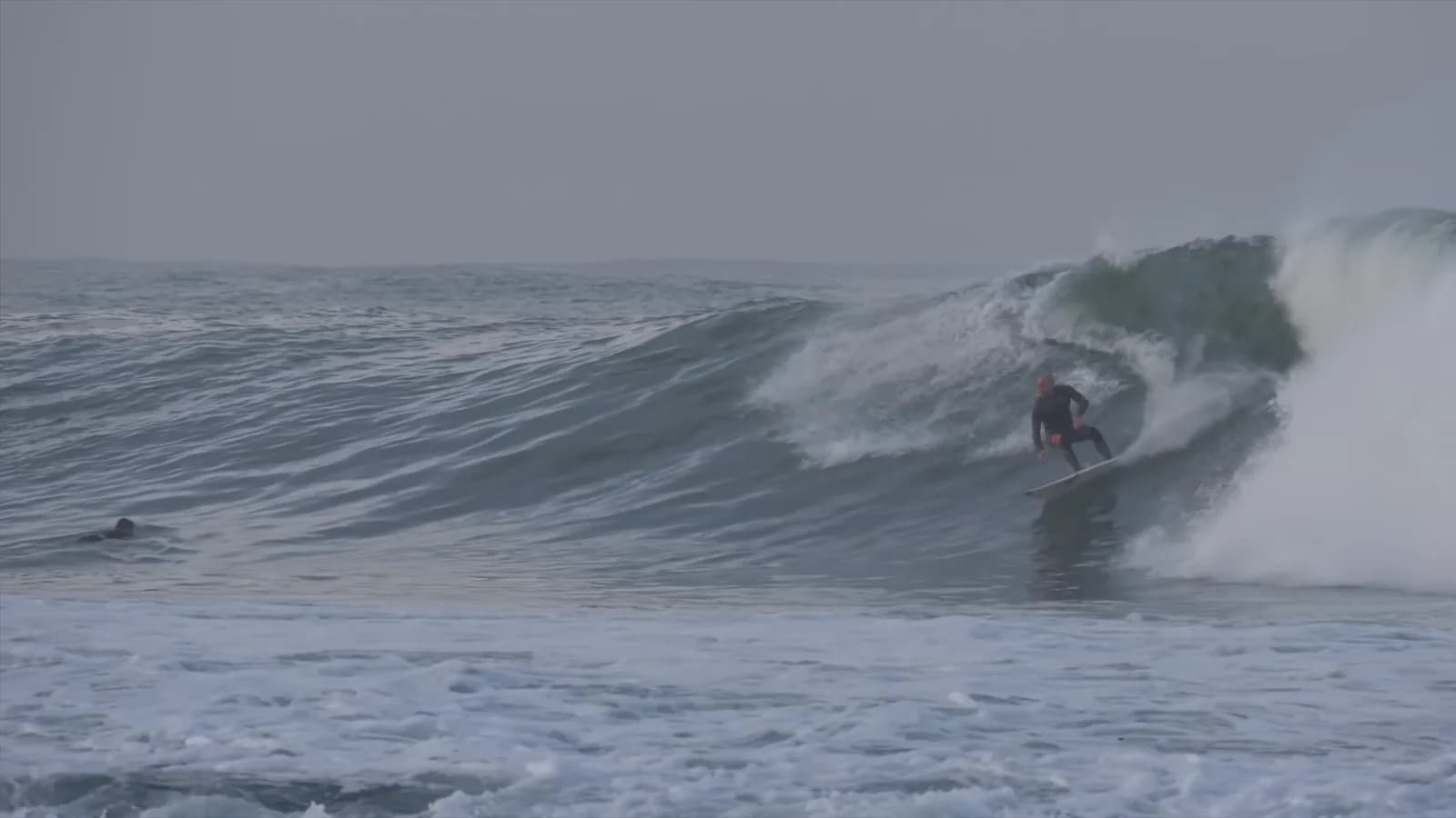 Surfer dropping into a steep breaking ocean wave